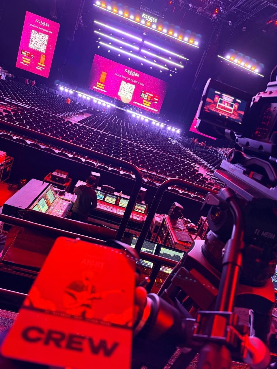 Broadcast camera overlooking a large indoor arena stage