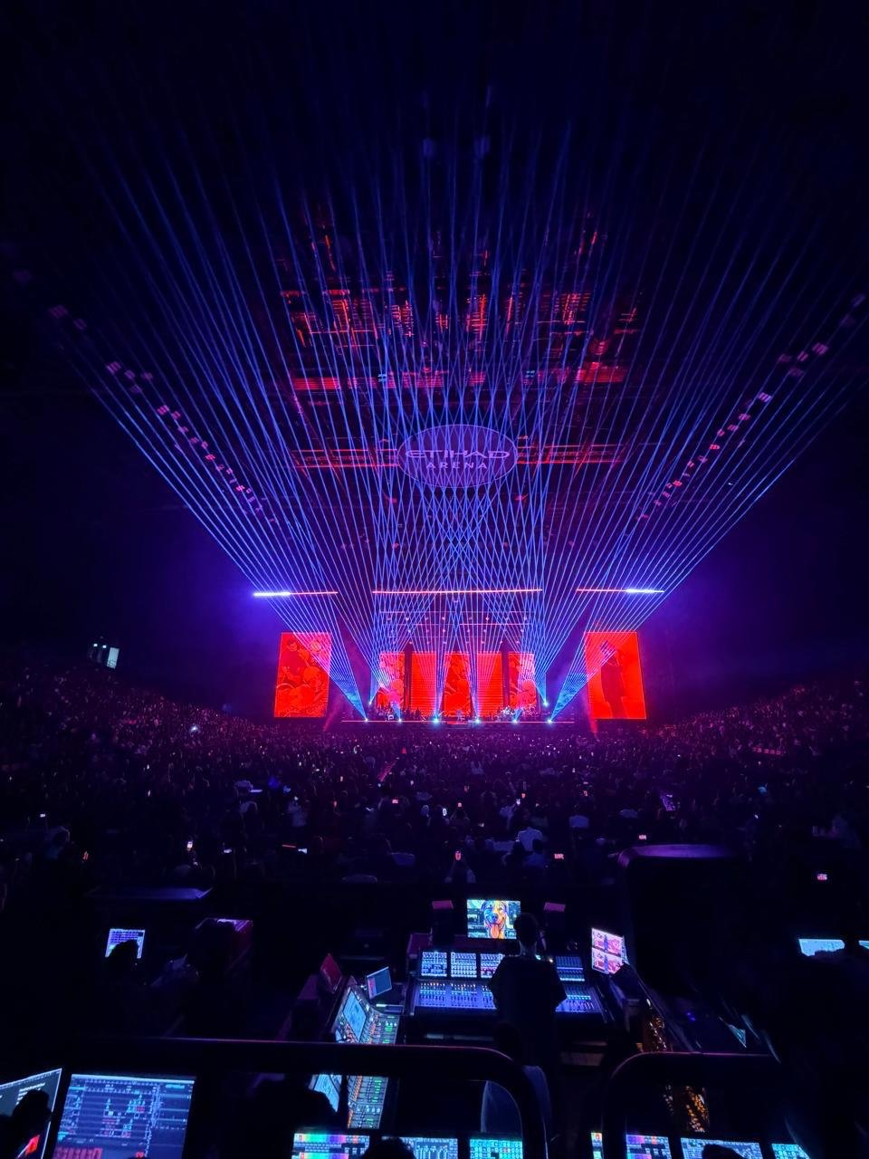 Large arena concert with laser lighting and control desks